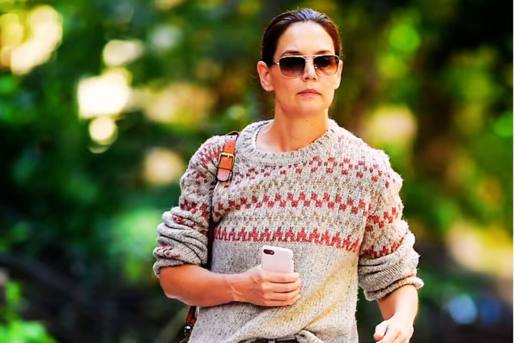 Katie Holmes walking in New York City, dressed in an oversized, multi-colored graffiti sweater